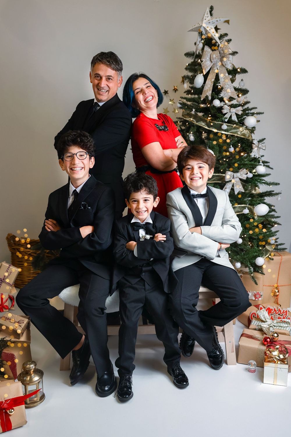 A series of holiday portraits showing formal wear and Christmas decorations with a decorated tree and wrapped gifts.