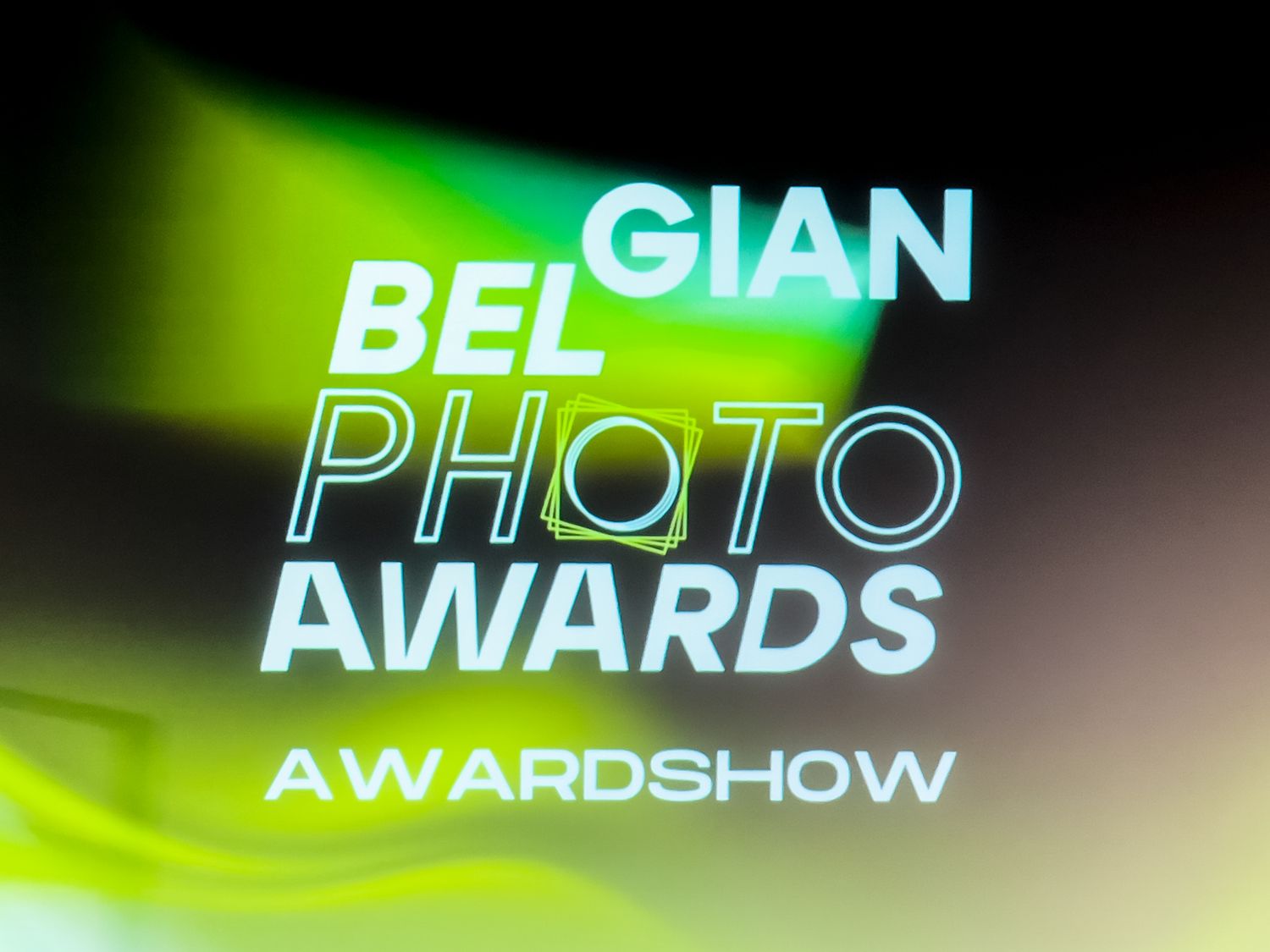 Glowing green text displays 'PHOTO AWARDS' and 'AWARDSHOW' against a dark background in a modern design.