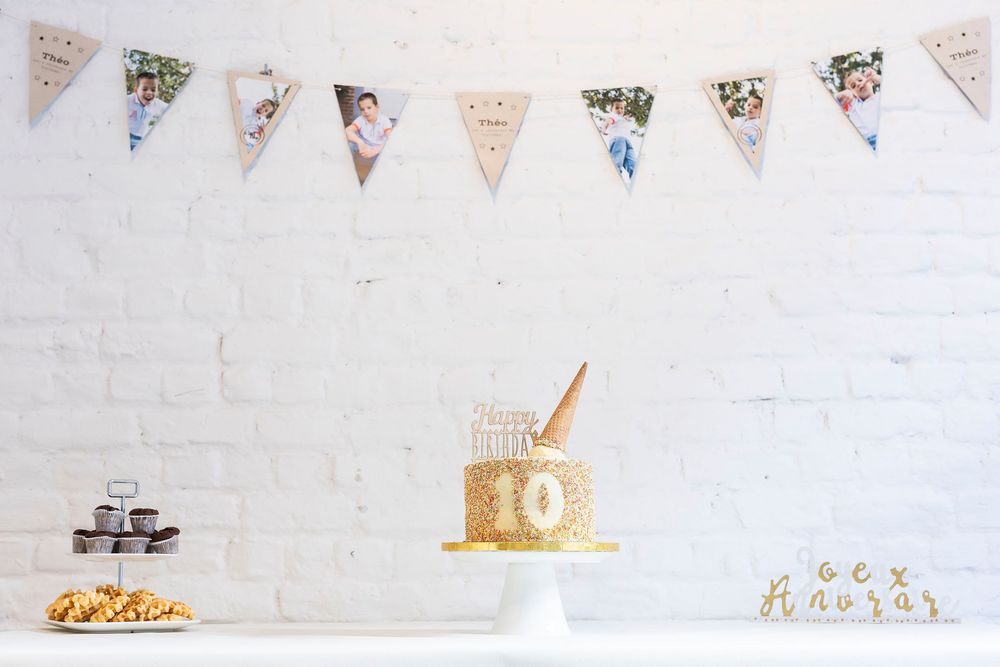 Decorative party bunting with triangular flags hanging against white wall.
