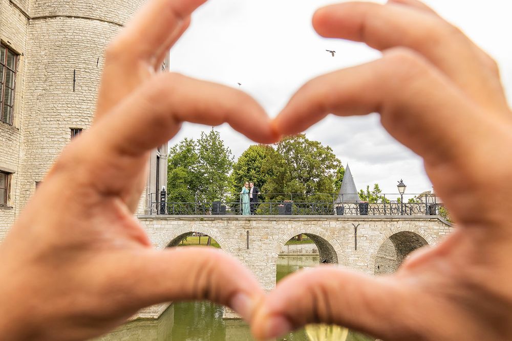Hands forming heart shape gestures against architectural background.