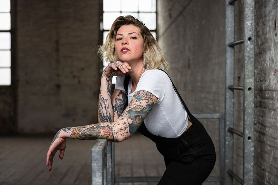 Fashion photoshoot in an industrial concrete space with dramatic lighting.