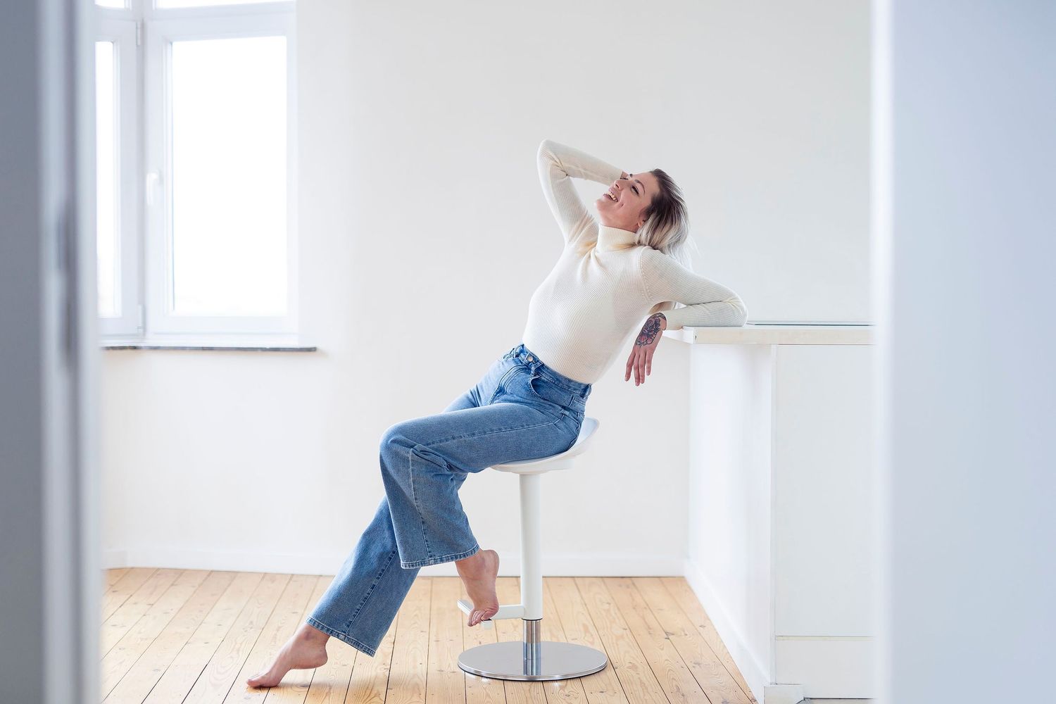 Minimalist white studio space with wooden floors and natural lighting.