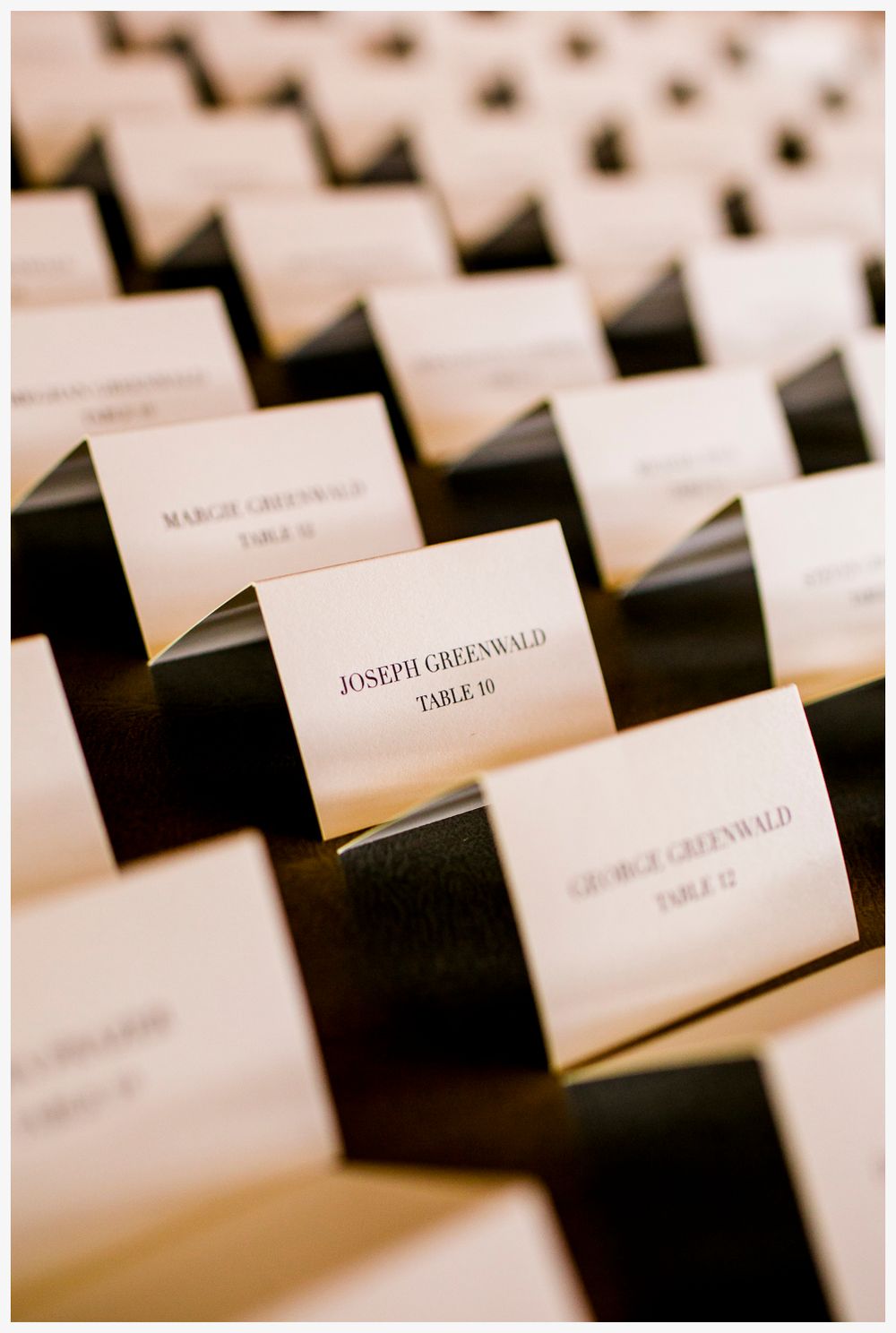 Elegant place cards arranged in rows for wedding guest seating assignments.
