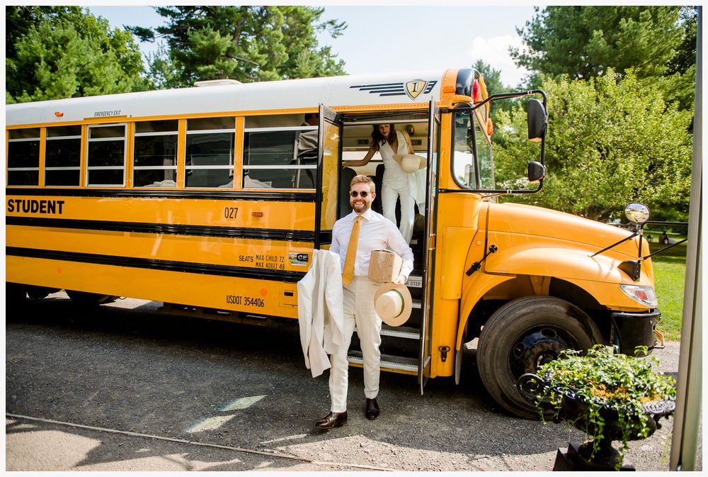 Yellow school bus parked outdoors on sunny day with greenery in background.