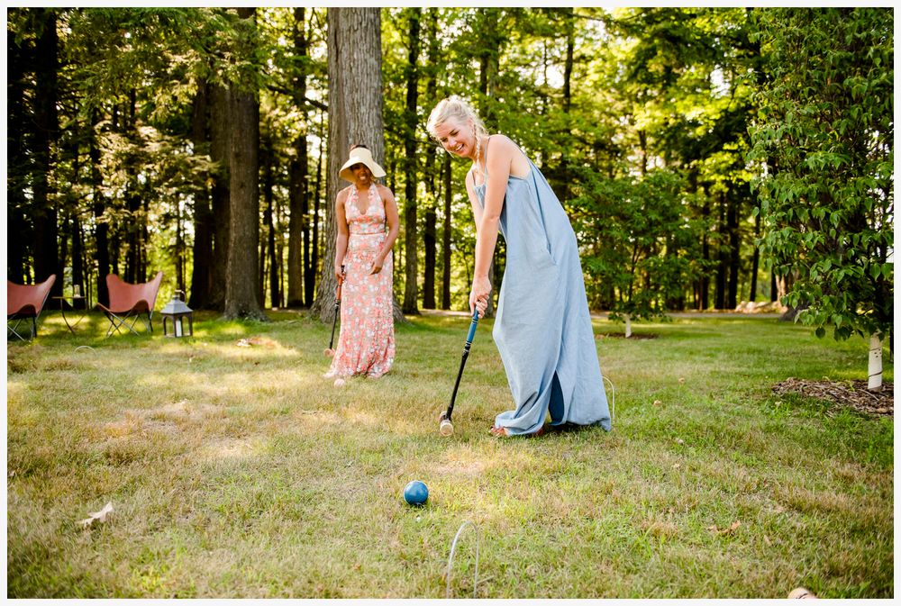 People playing croquet on green lawn during outdoor summer event.
