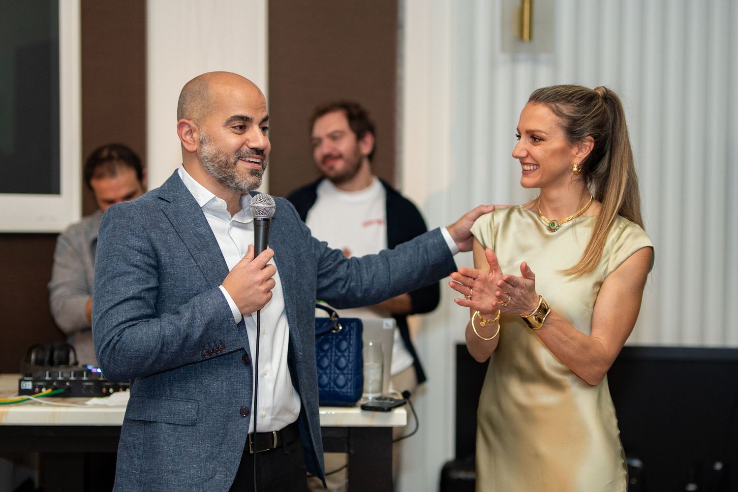 Husband and wife laughing together at a birthday celebration in Bostons Four Seasons Hotel. Event photography by Leah Ramuglia.
