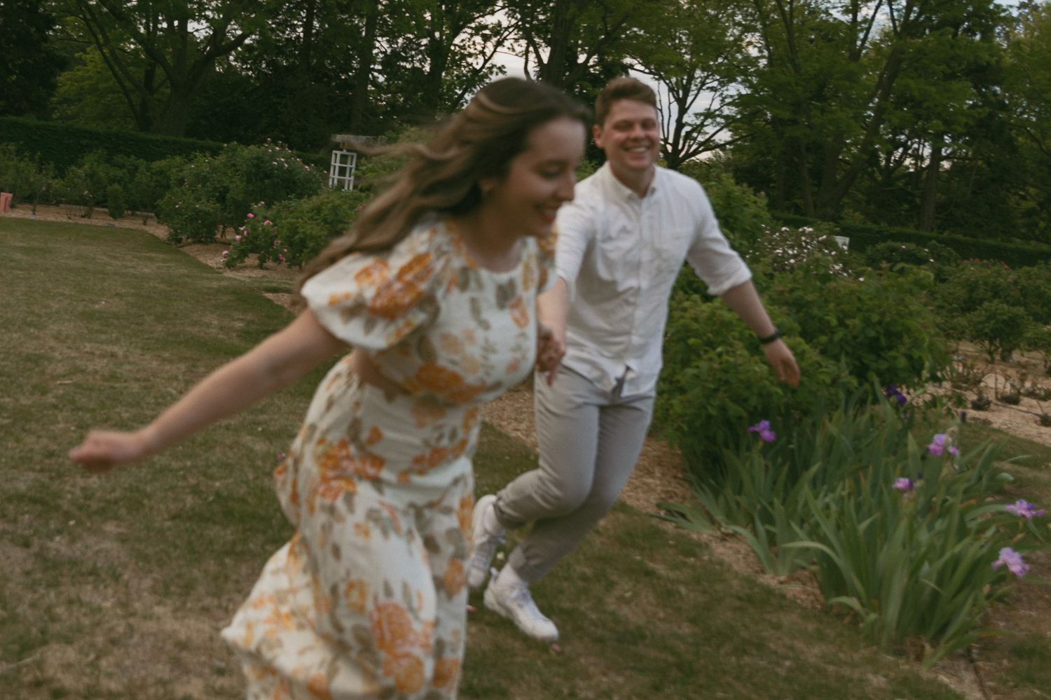 A couple running through grass with blurry motion.