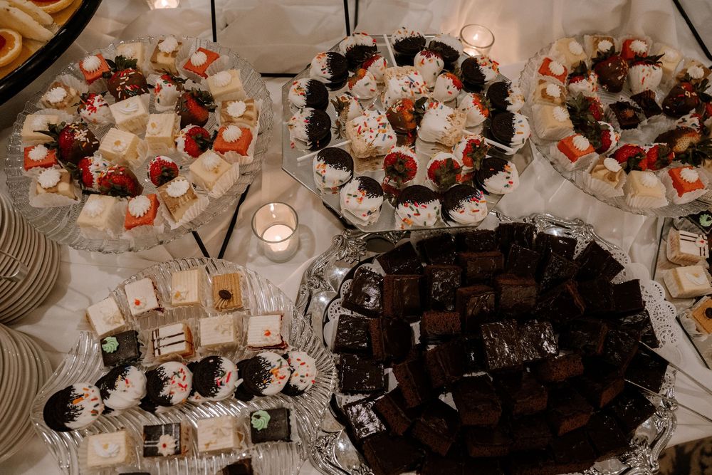 Elegant wedding reception tables decorated with floral centerpieces, candles and place settings in white and blush tones.