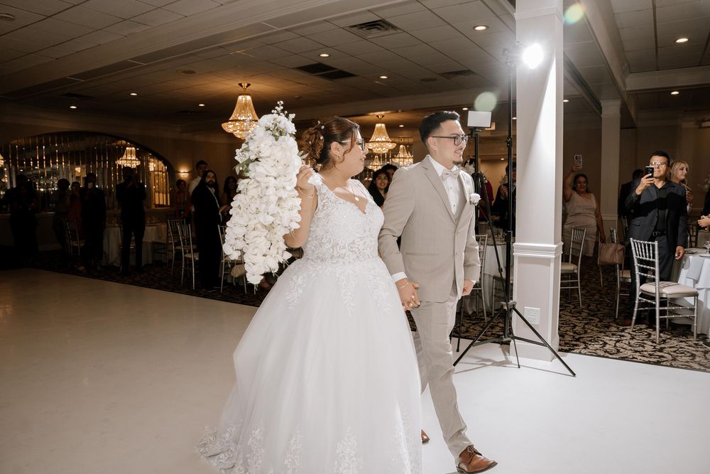 Spacious wedding ballroom with white decor and soft lighting creating an elegant celebration space.