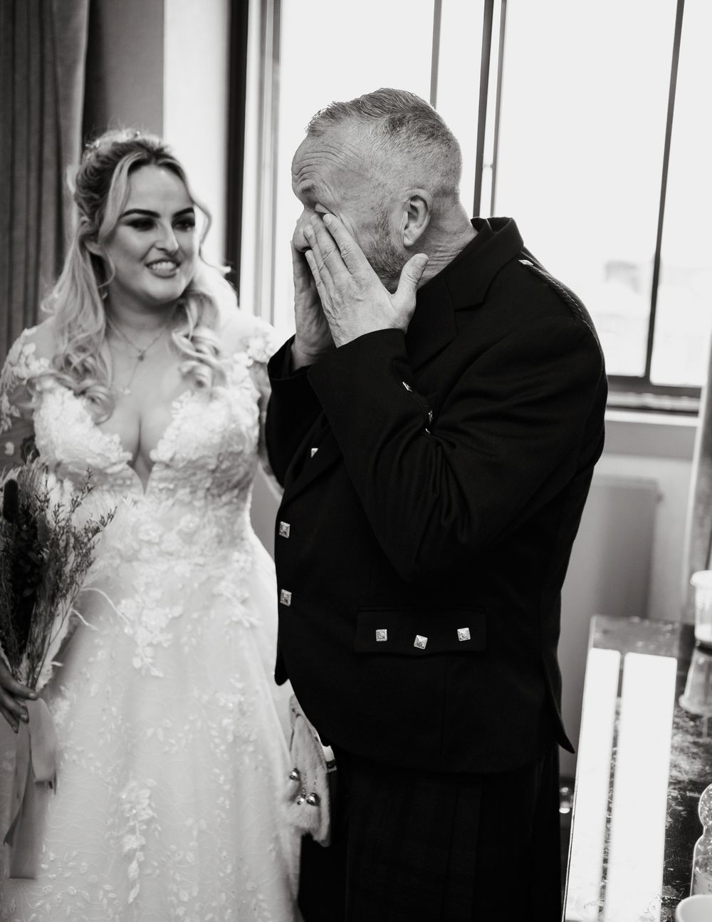 A series of black and white wedding photos showing a couple in formal attire sharing emotional first look moments.