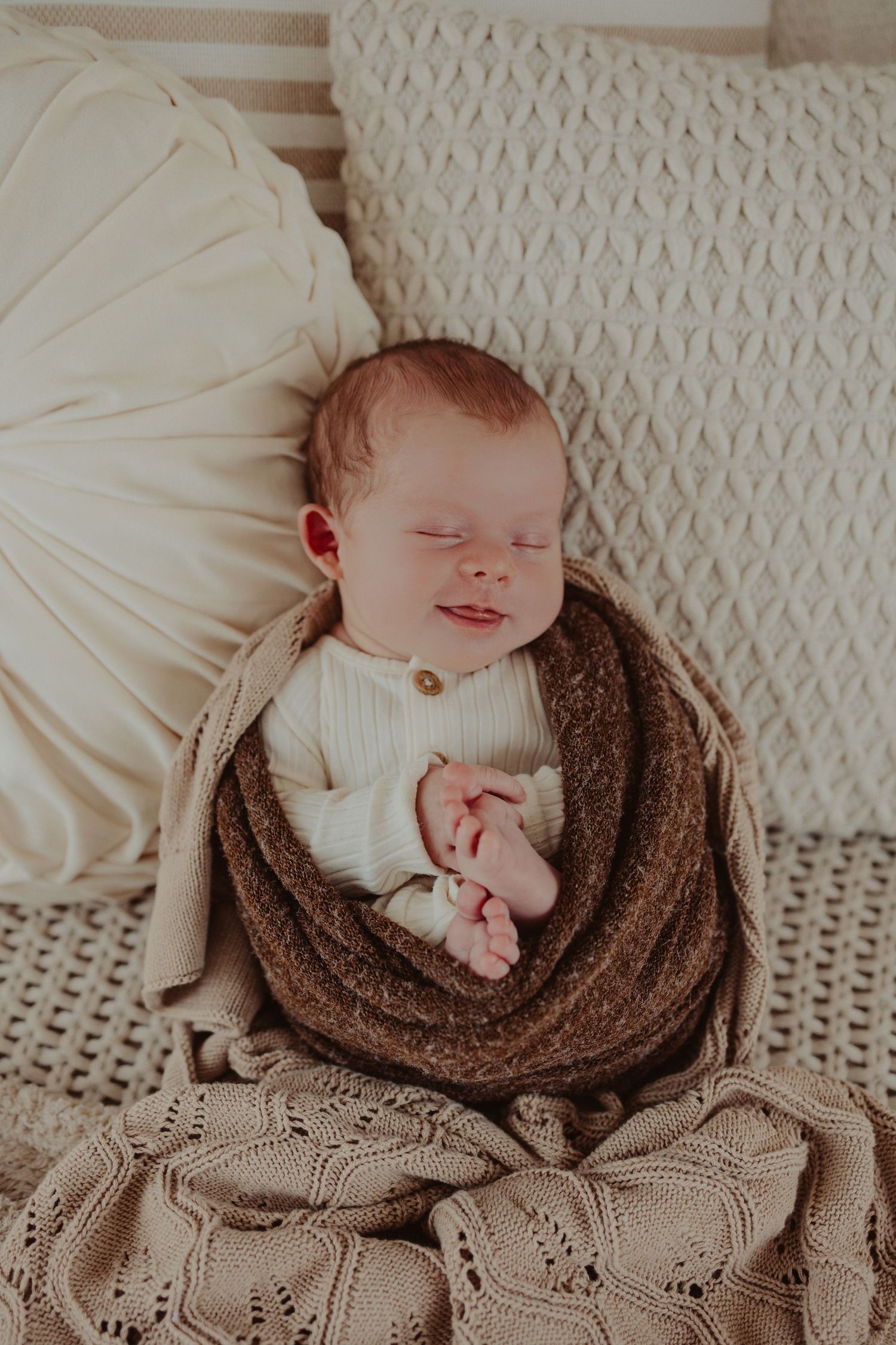 newborn baby smiles in his warm wrap- newborn photography session