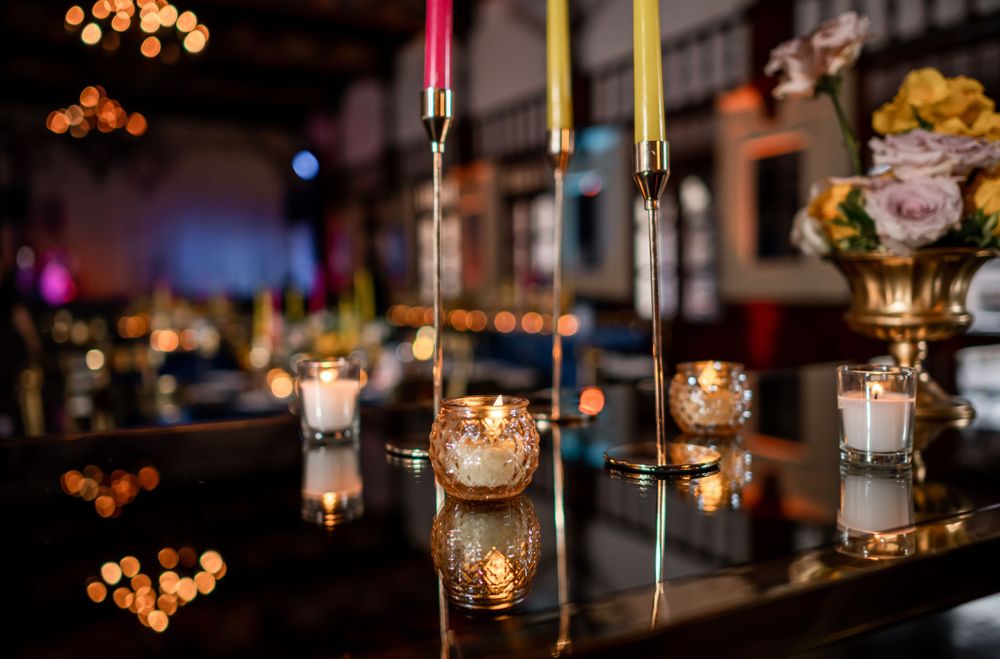 Glowing candles and elegant glassware create an intimate wedding reception atmosphere.