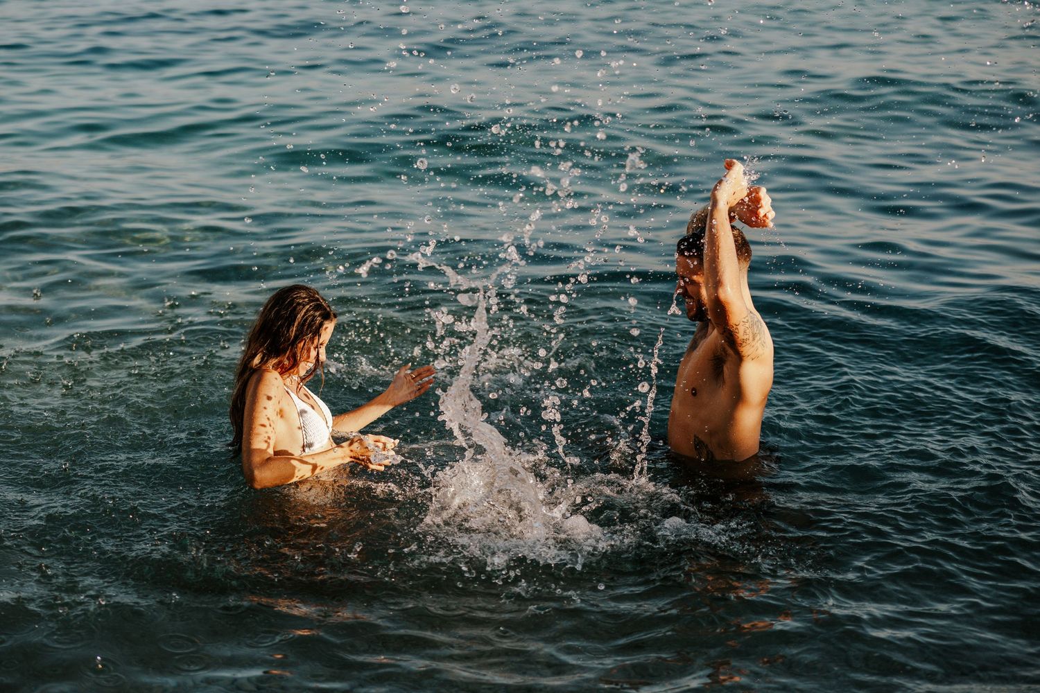 couple splashing in the sea off the coast of Amalfi Coast Italy