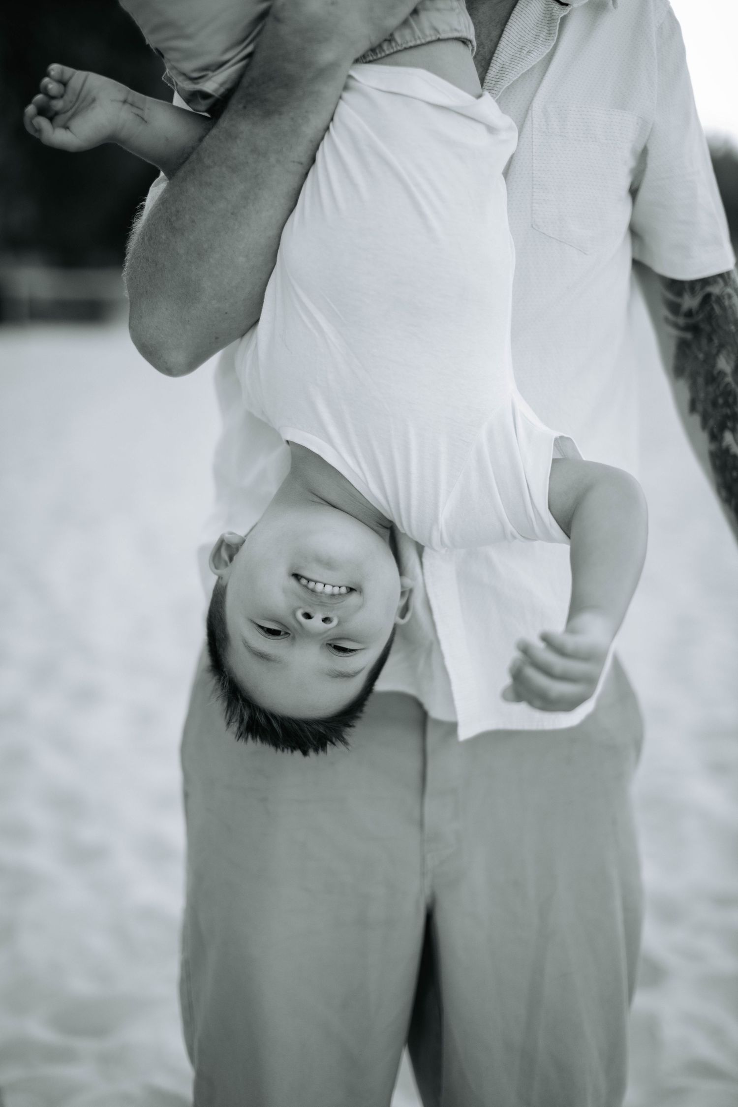 Black and white photo of playful bonding moment on the beach.