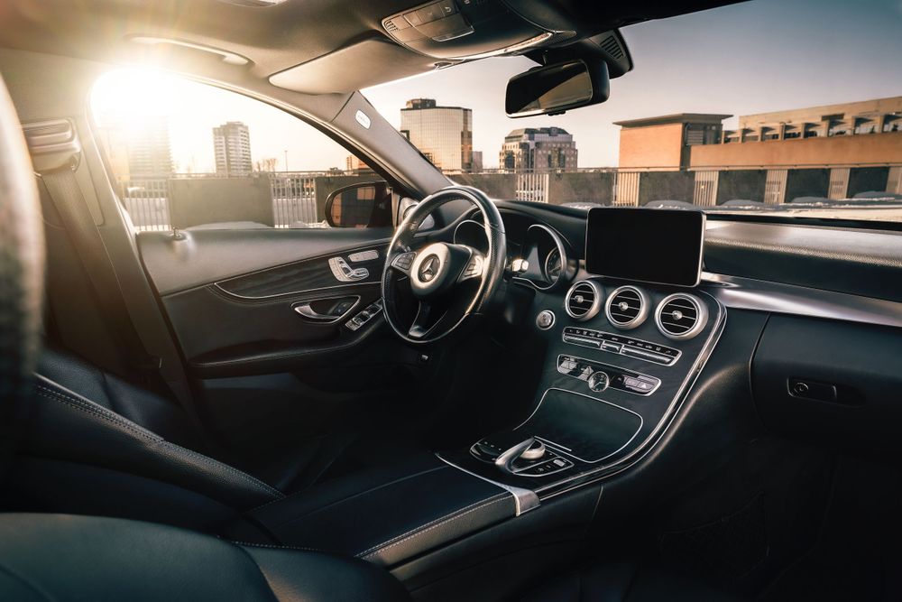Luxury car cockpit with sunlight streaming through windshield highlighting digital displays. Mtlshutter photography