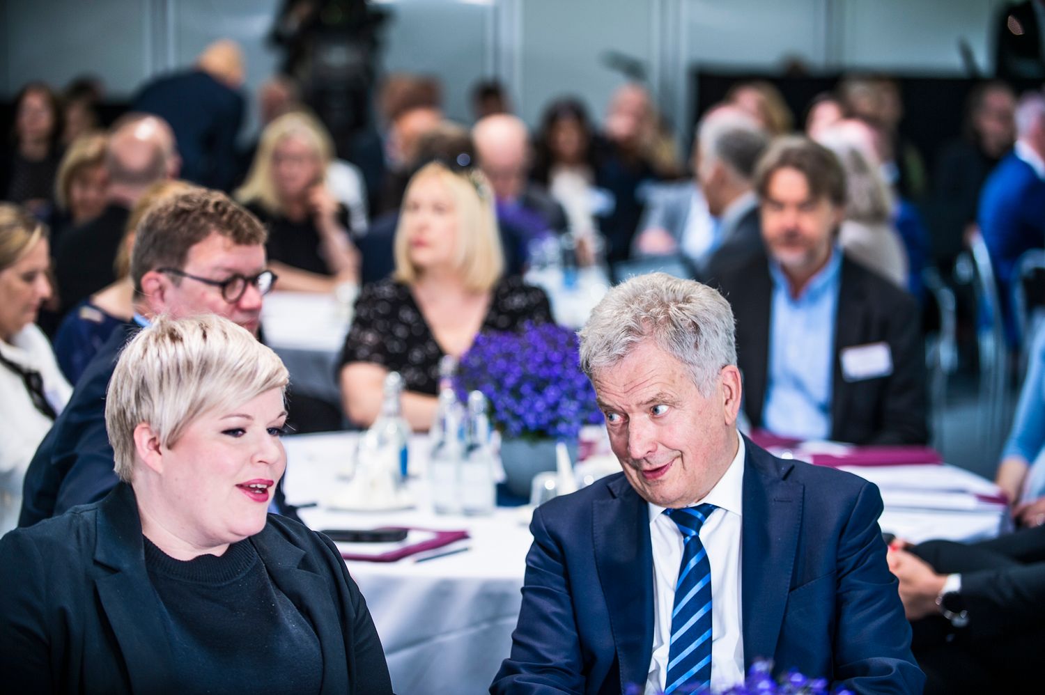 Suomen tasavallan presidentti Sauli Niinistö puhuu naisen kanssa