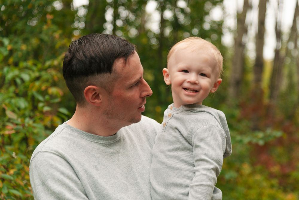 A tender moment between parent and child outdoors during autumn.