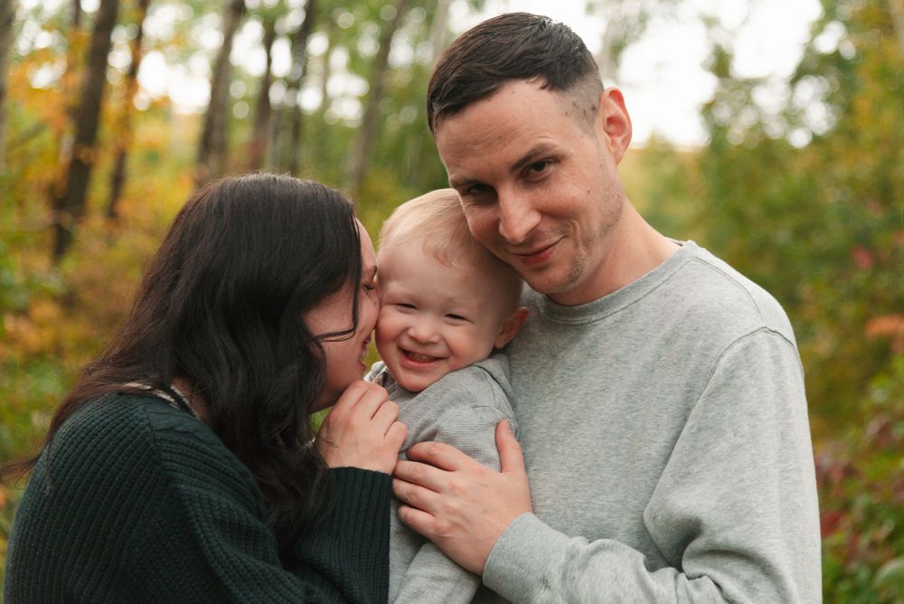 An intimate family moment shared outdoors during fall season.