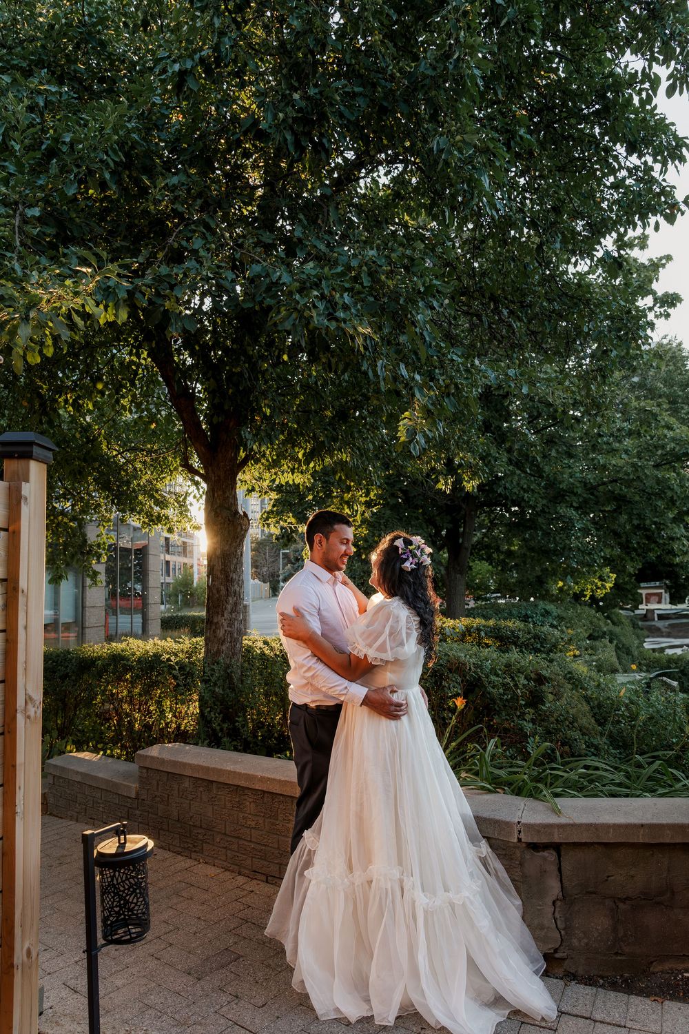 Candid wedding photo of bride and groom standing together in a garden during sunset near woodstock, ontario.