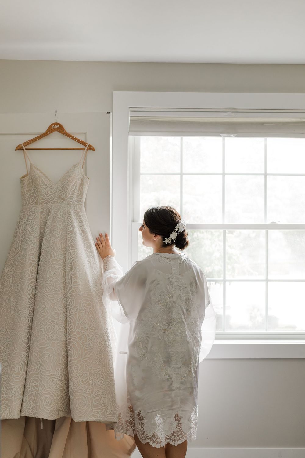 Bride looking at her dress handing before getting ready for a calm wedding photo moment near woodstock, ontario.