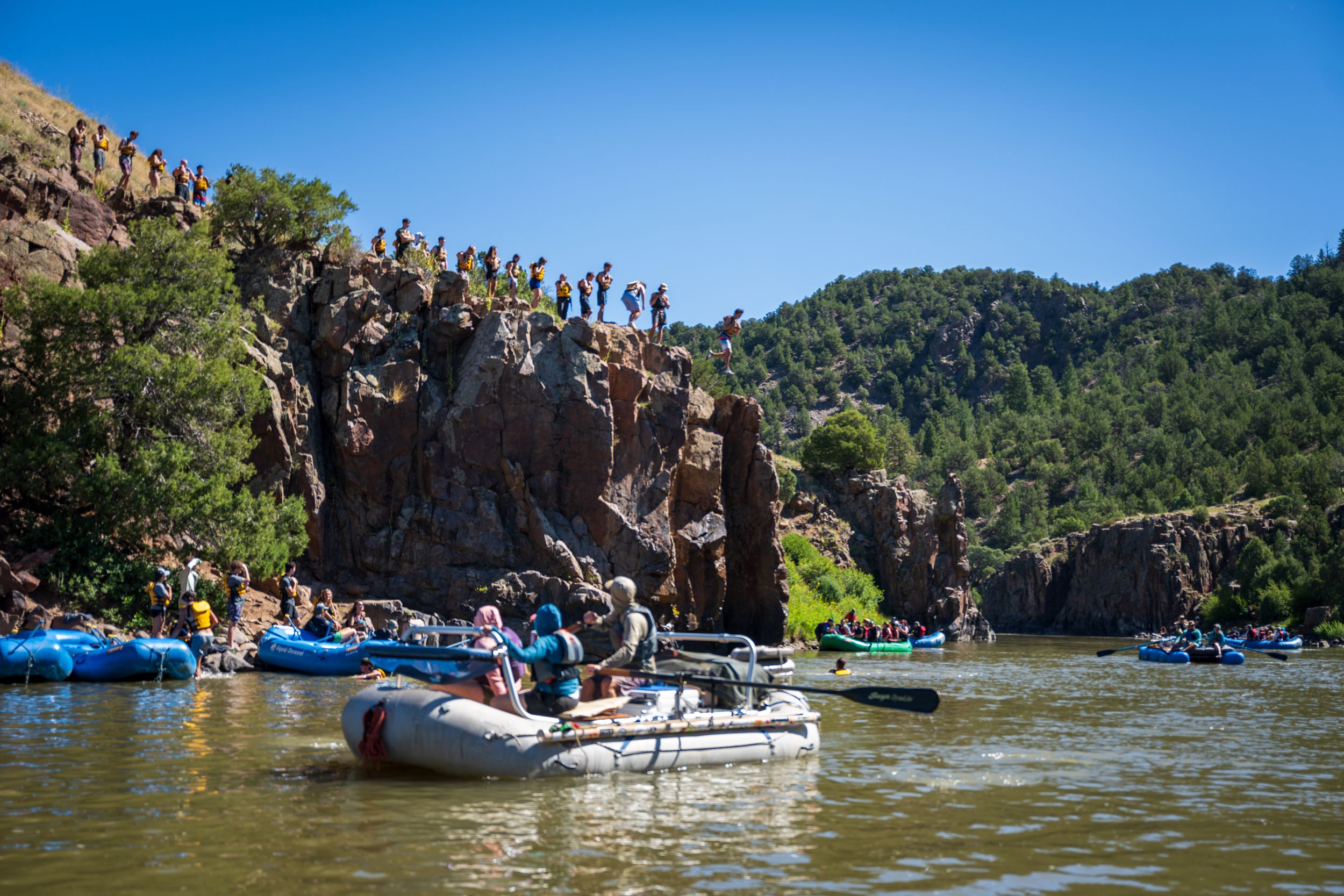 Image of cliff jumpers on the CO River in Kremmling, CO by Denver Hospitality, Travel & Tourism photographer Captain Colorado Photography.