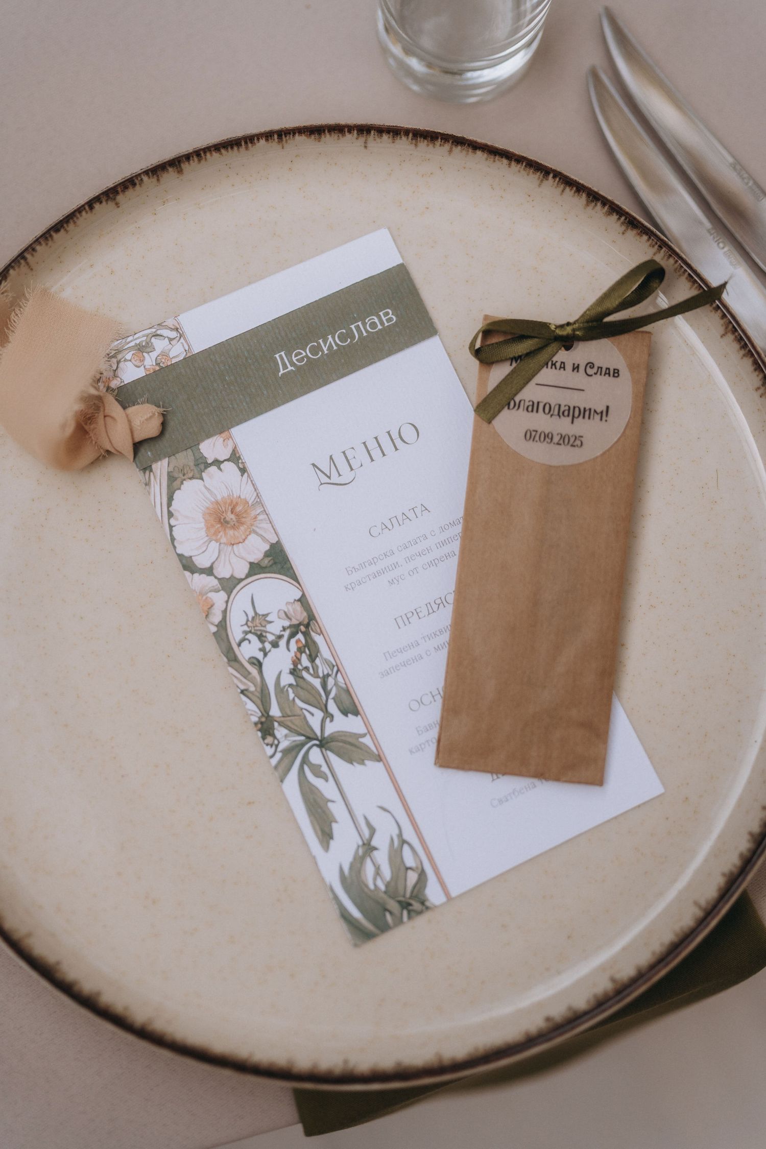 Elegant wedding menu card with floral design and Cyrillic text on a ceramic plate with kraft paper envelope.