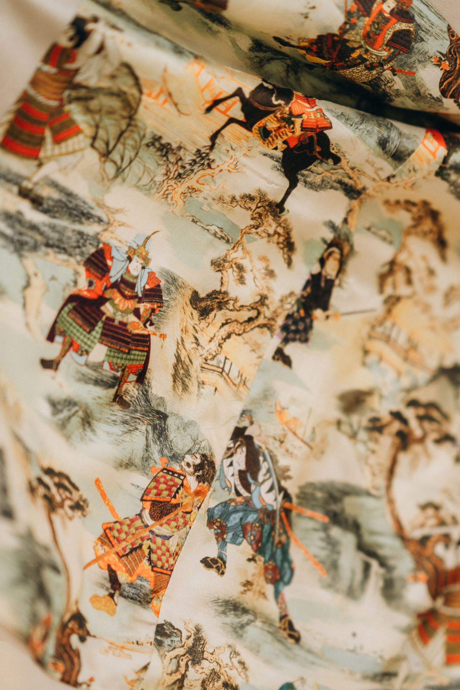 Fabric featuring traditional Japanese samurai warriors in colorful armor, illustrated in classic ukiyo-e painting style on cream background.