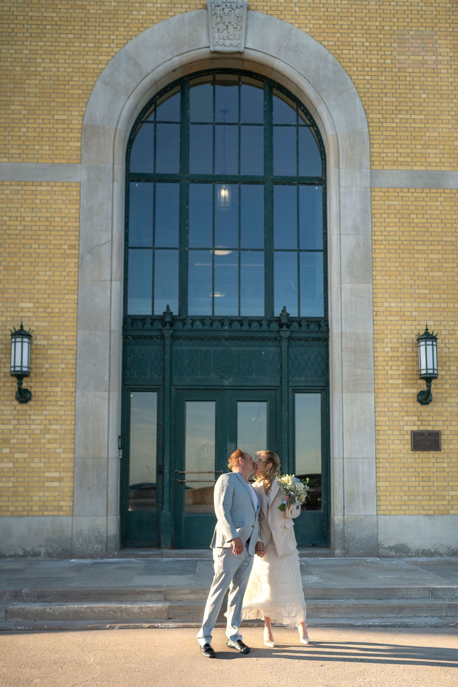 Couple exchanging vows in elegant indoor wedding ceremony with officiant in red stole and white orchid decor.