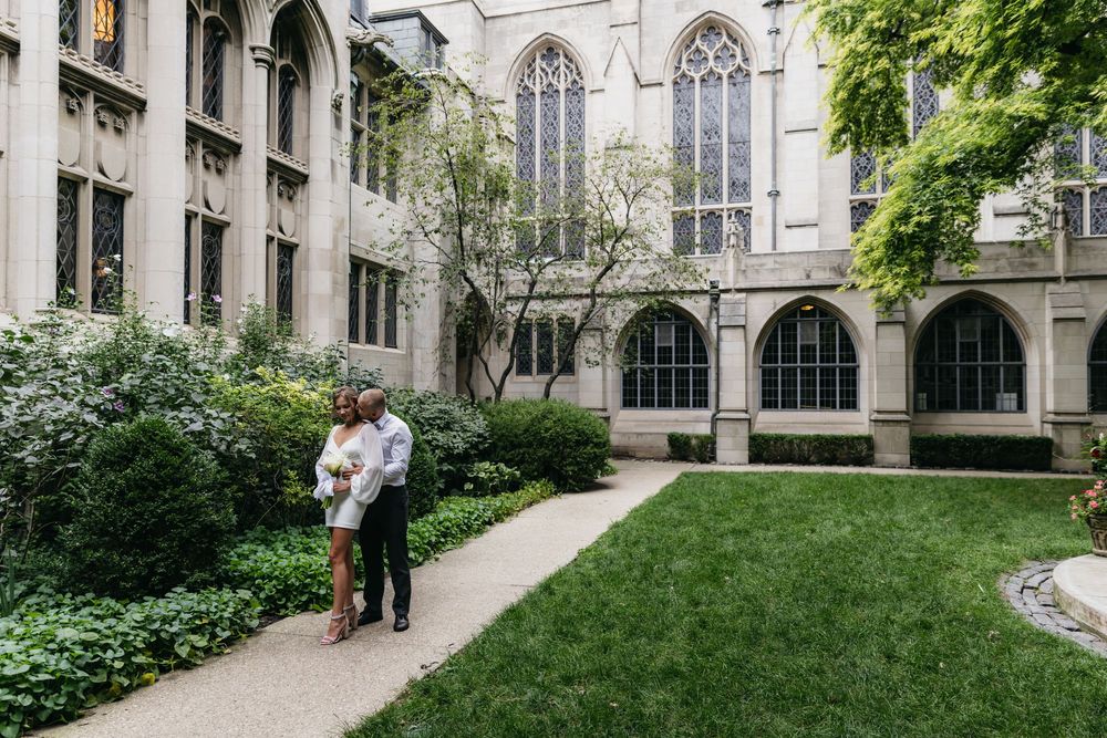 Couple embracing on the grounds of Fourth Presbyterian church in downtown Chicago during their engagement session