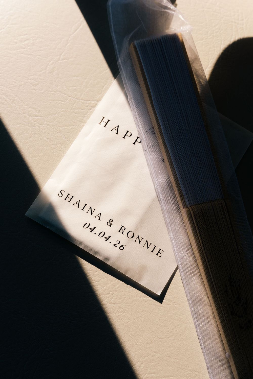 Custom wedding favor bag printed with Shaina & Ronnie 04.04.26 alongside dark incense sticks in clear packaging.