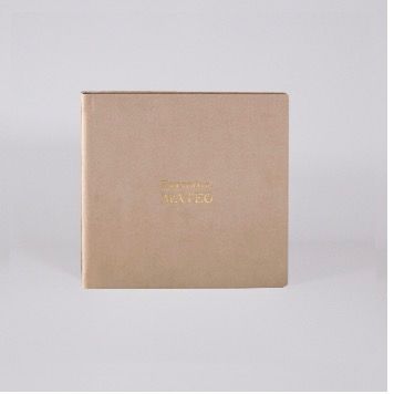 Beige linen-bound square photo album with gold foil text embossed on the cover.