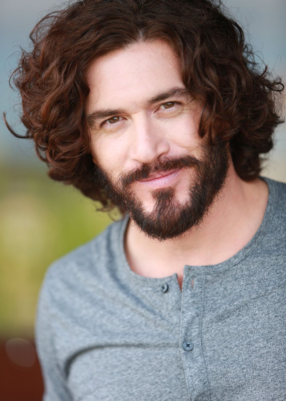 Series of casual headshots featuring curly hair and a gray henley shirt.