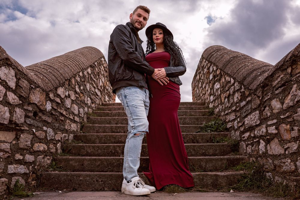 férj és várandós felesége állnak a lépcsőn a kismama fotózáson