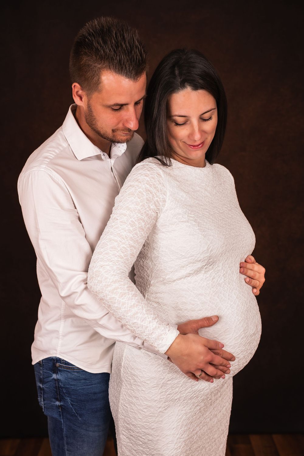 kismama és férje gyönyörködik a pocakban