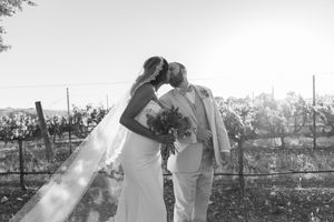 Black and white romantic moment between newlyweds in vineyard setting.
