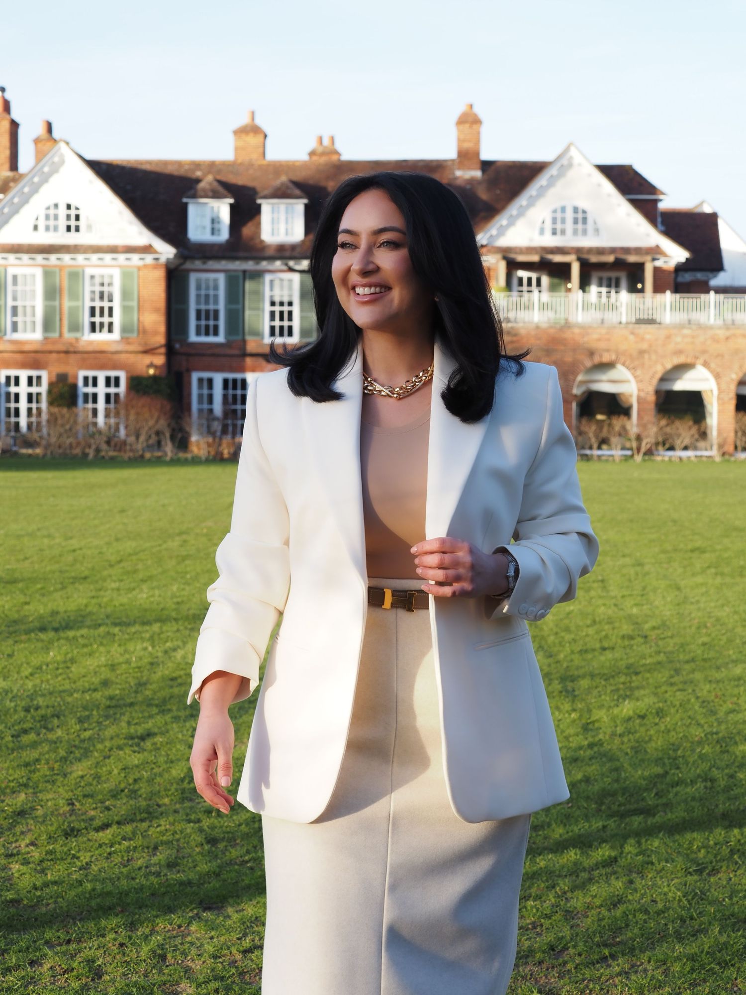 Magazine cover of Dorset Living featuring someone in a light blazer smiling outdoors in front of a brick mansion.
