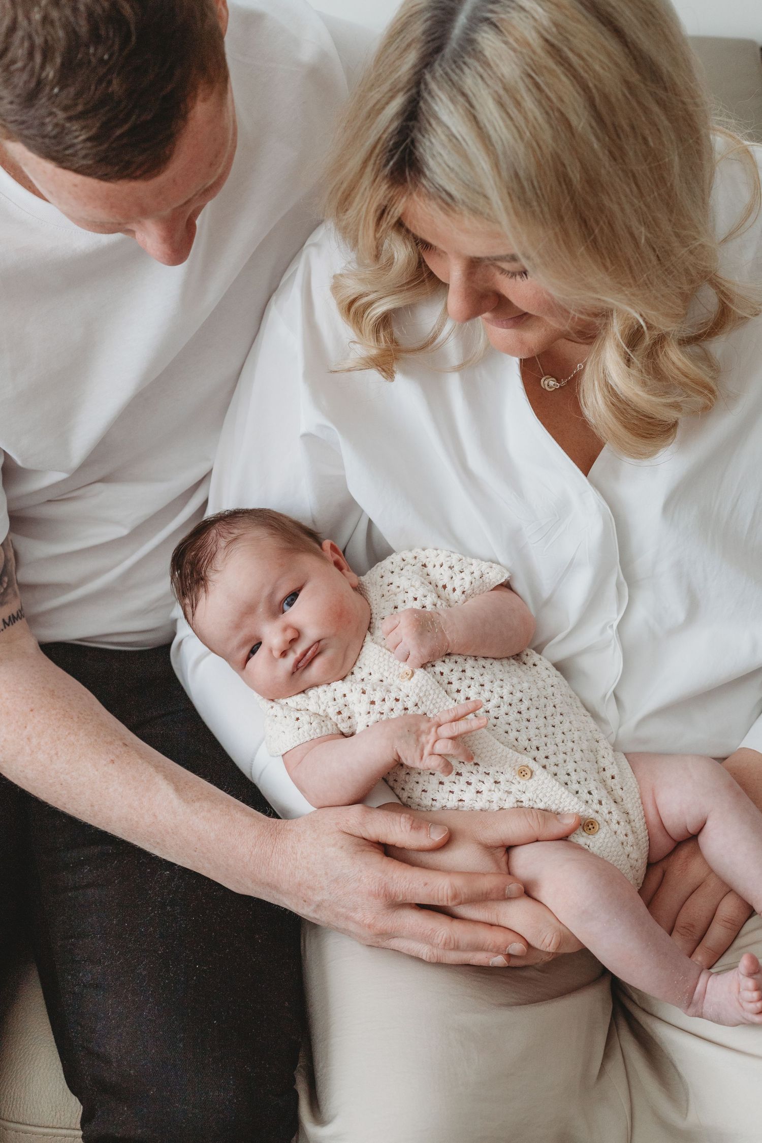 Intimate in-home newborn photography session featuring new parents and baby — specialist family photographer Hertfordshire and beyond