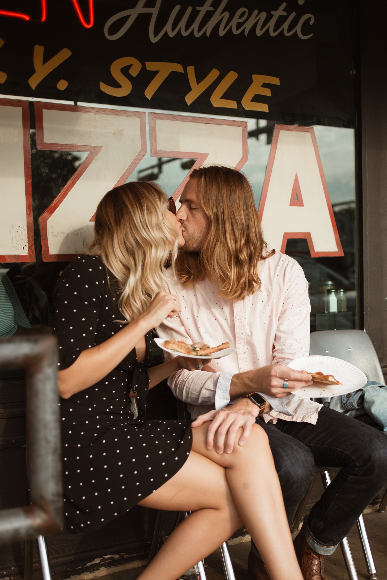 Couple sitting casually in front of a storefront with 'Authentic' and 'Style' signage.