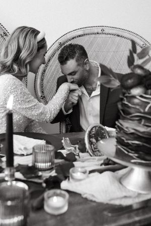 Intimate black and white photo of romantic moment at decorated wedding table.