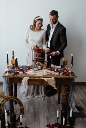 Elegant wedding table setting with candles and vintage decor in moody lighting.