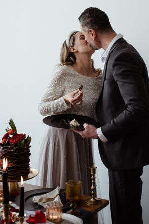 A couple shares an intimate moment over dessert at an elegantly decorated table.