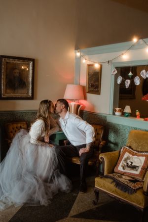 Intimate moment captured in vintage-style room with string lights and antique furniture.