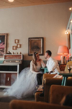 Retro-styled wedding scene in a vintage lounge with piano and mid-century furniture.