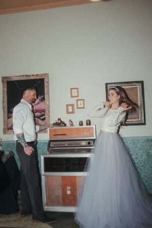 Retro-styled wedding photo with vintage jukebox in background.