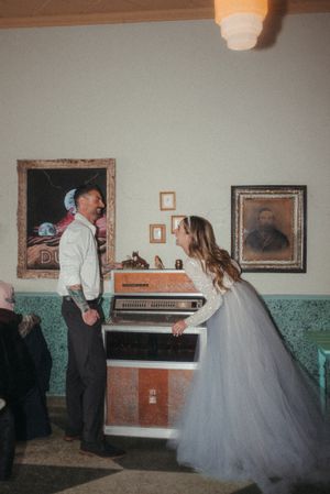 Vintage-style wedding scene with couple by jukebox.