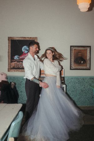 A joyful dancing moment captured in a retro-styled room with vintage posters.