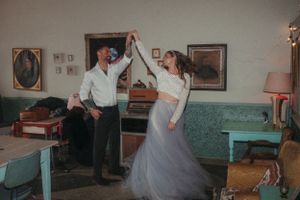 A joyful dancing scene in a retro-decorated room with mint green furniture.