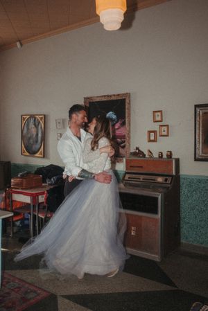 A couple dances in a vintage room with retro decor and wooden accents.