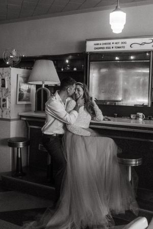 Vintage bar setting with couple sharing romantic moment in black and white photography.