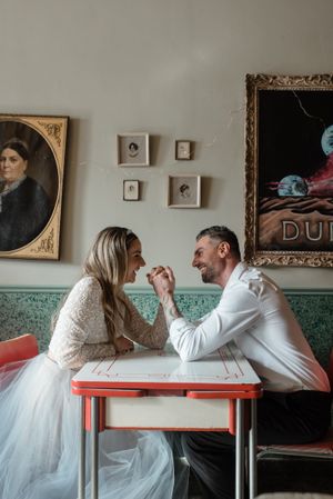 Retro diner scene with vintage portraits and teal walls creating romantic atmosphere.